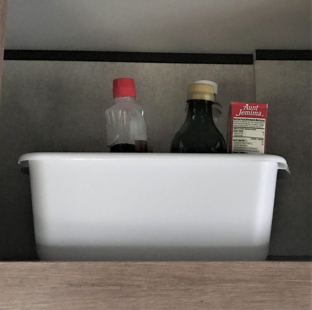 photo showing white storage bin in overhead cabinets of Jayco travel trailer