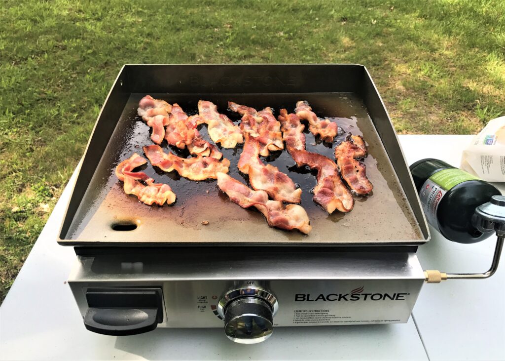 bacon cooking on Blackstone grill