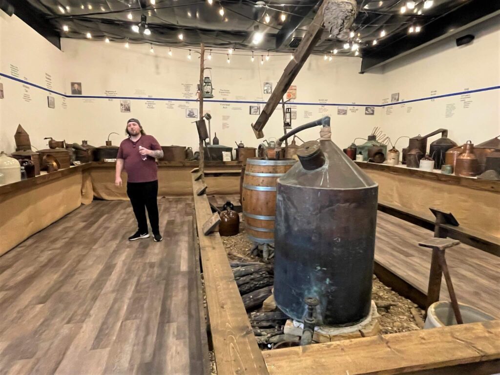 Tour Guide Dalton giving a tour of Moonshine Museum at Ozark Hills Winery