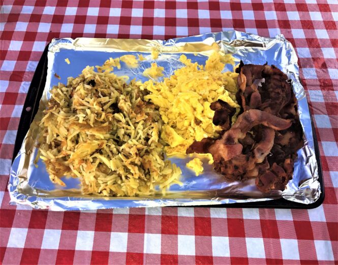Hashbrowns eggs and bacon cooked on a Blackstone Grill at the campground